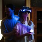 A couple experiences virtual reality gaming with headsets and controllers in a cozy home setting.