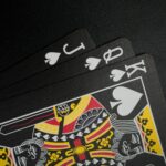 Close-up of black playing cards with focus on the King of Spades in a spade hand.